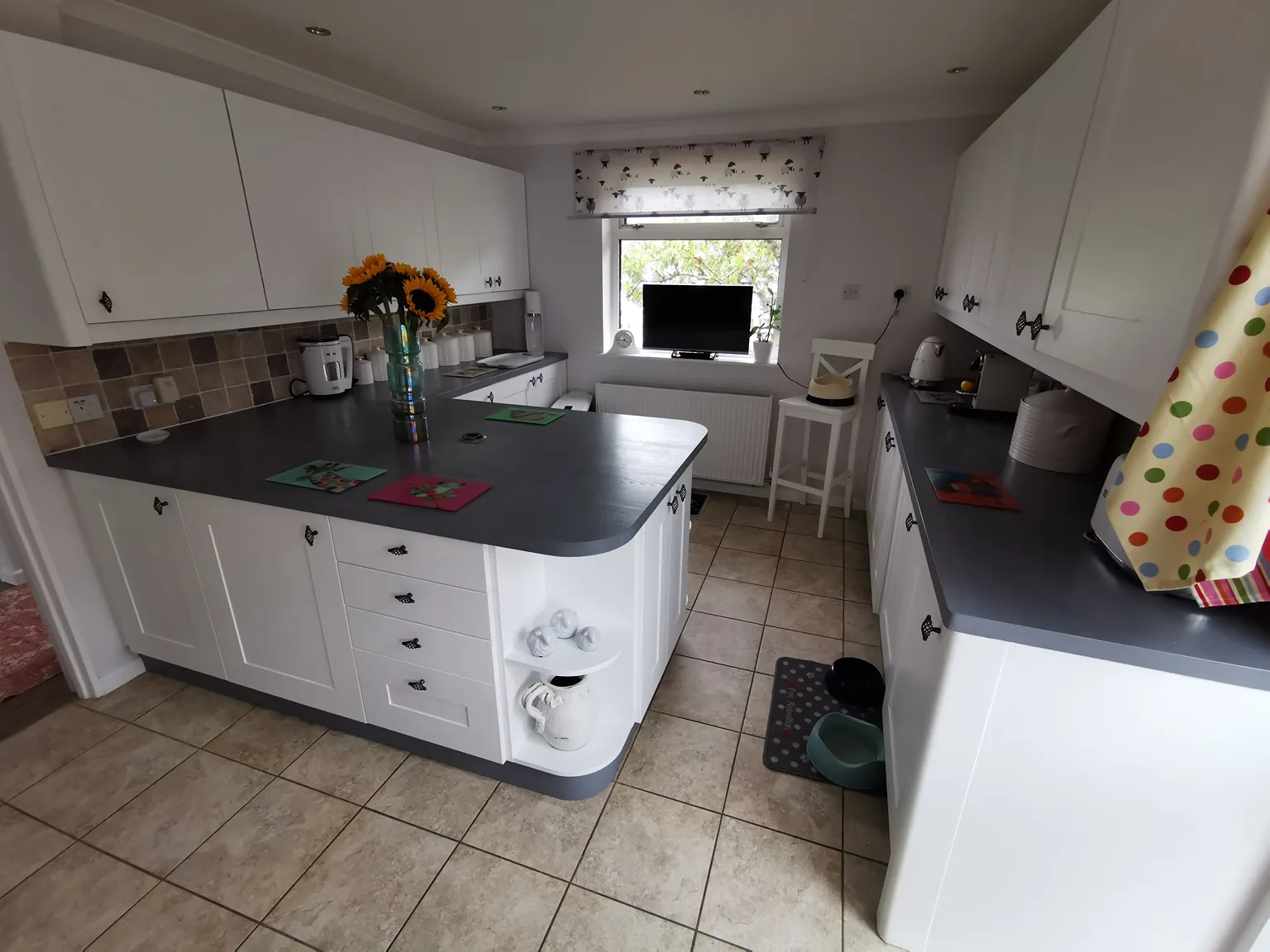 Newly painted kitchen units in white eggshell and a wood-stained kitchen worktop in gray